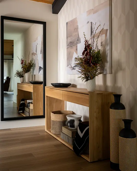 Grace Blu Travertine entryway with light wood console, abstract art, baskets, and black-framed mirror for a serene, modern look.