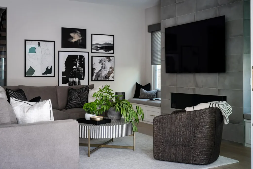 Contemporary living room with gray sectional sofa, gallery wall art, modern fireplace and indoor plant, designed by Grace Blu Interior Design.