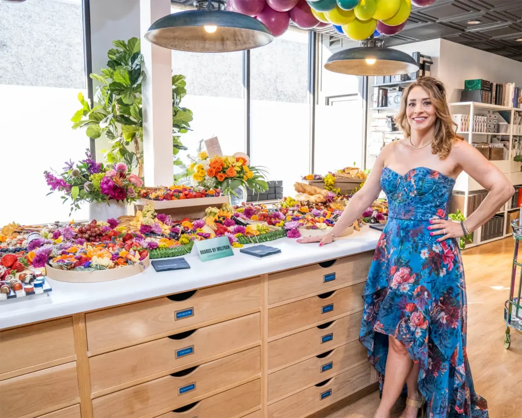 Grace Blu founder, Rona Graf, standing next to charcuterie boards