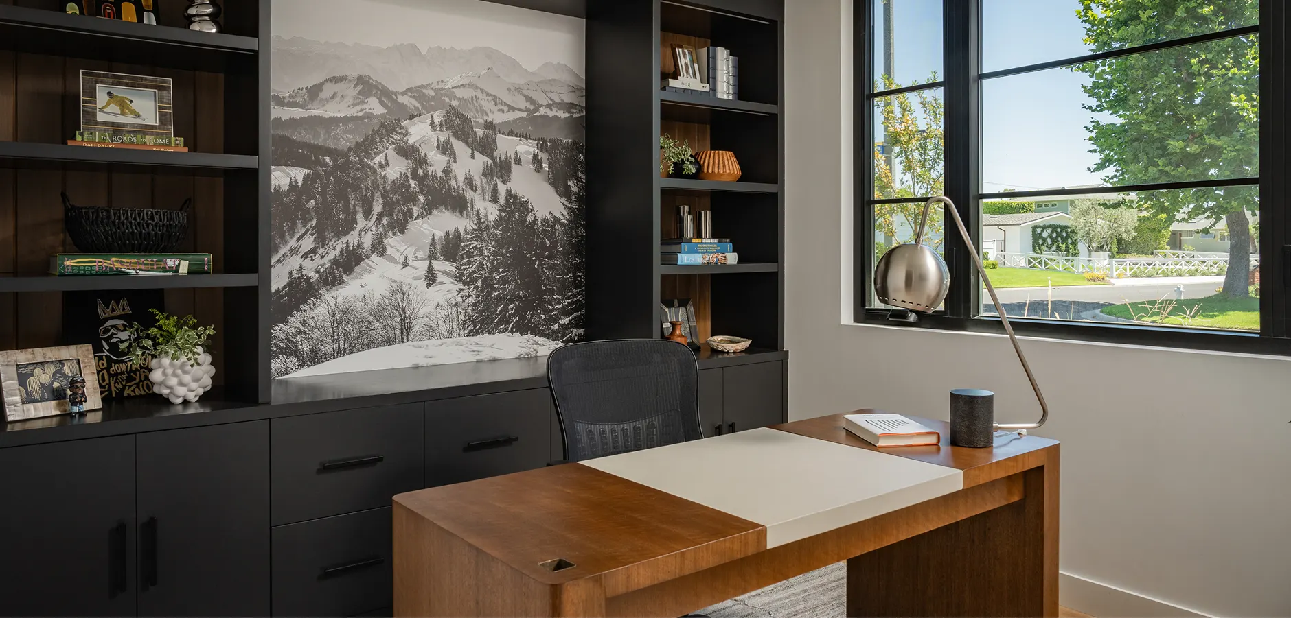 modern office with black cabinets and wood desk by window, wood accents, large black and white photo on wall