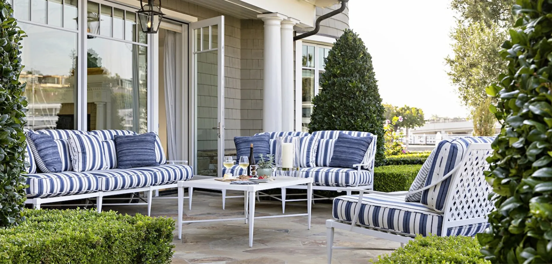 Bluffton patio with blue-and-white striped furniture before large glass doors.