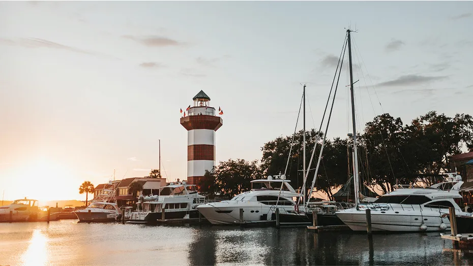 Sunset over Bluffton Bay in South Carolina, where yachts are anchored amid calm waters reflecting the warm glow of the setting sun