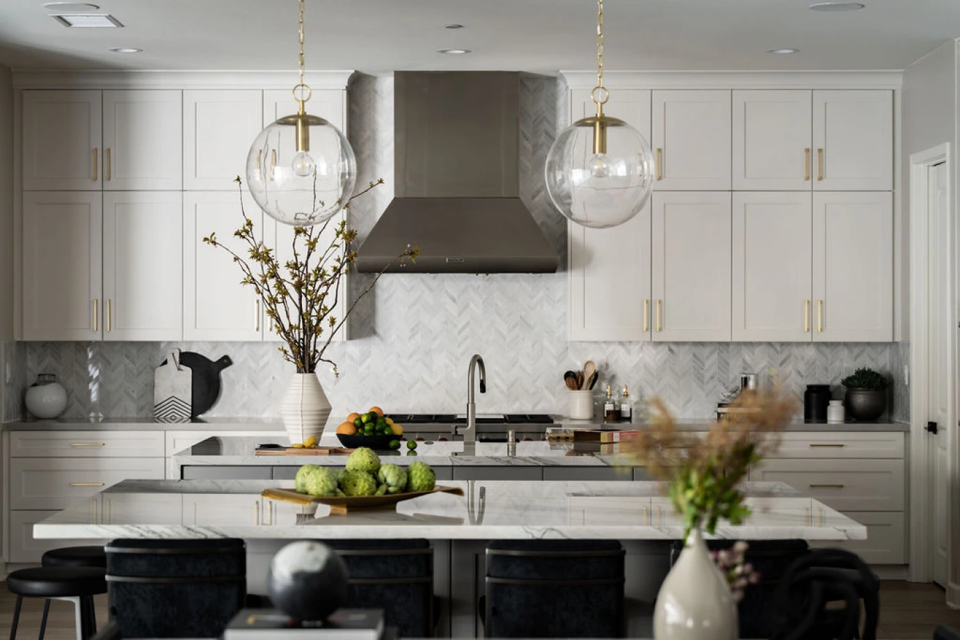 Trailmaster kitchen island with marble top, pendant lighting, and seating in open concept.