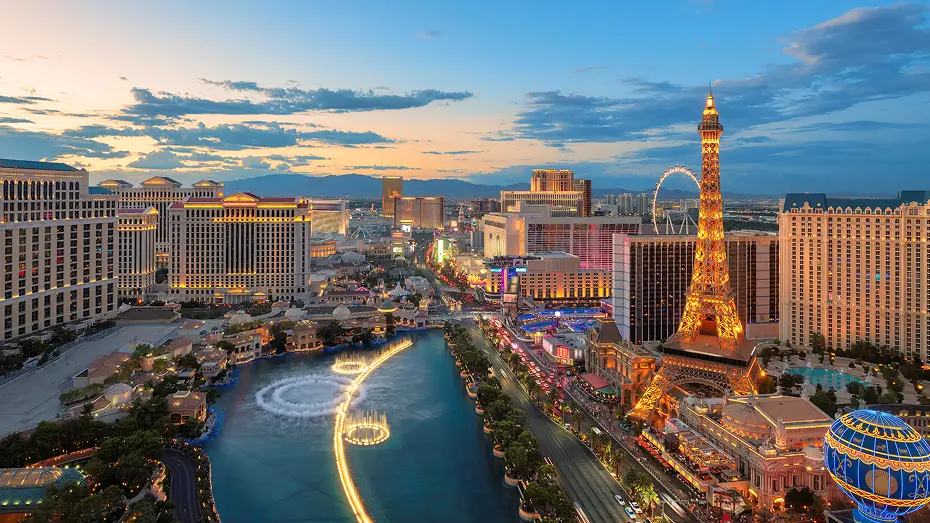 Aerial view of downtown Las Vegas during dusk with mini Eiffel Tower shown. Colors are vibrant and lights are displayed in buildings