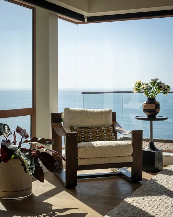 Grace Blu Va Va Views coastal corner with lounge chair, patterned pillow, side table, and floor-to-ceiling ocean views.