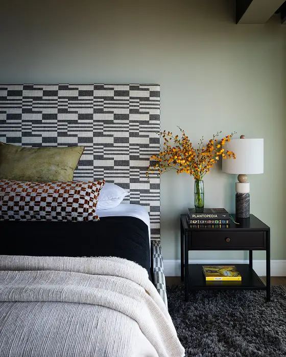 Grace Blu Va Va Views guest bedroom with geometric headboard, layered pillows, black nightstand, and orange floral accents.