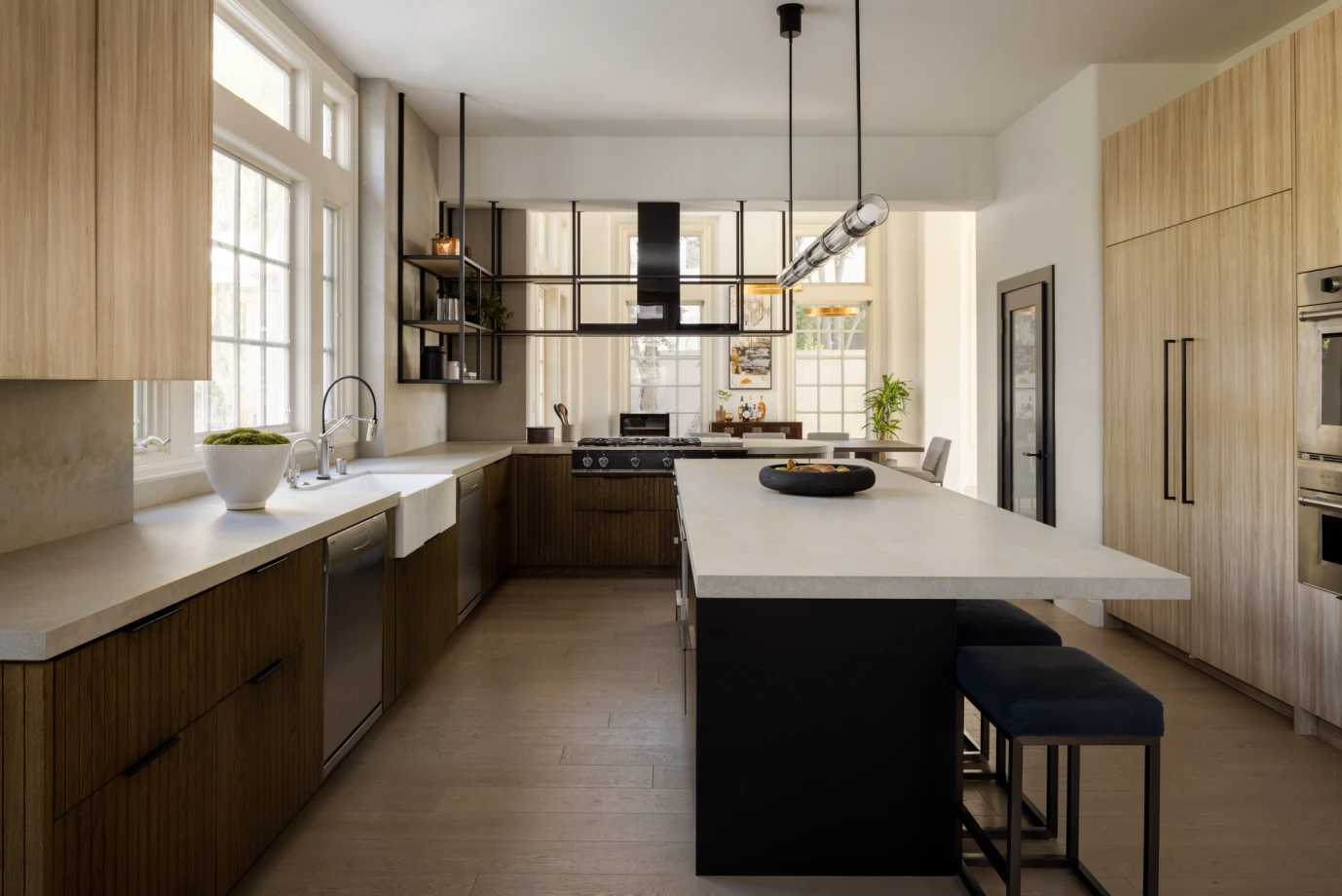 Grace Blu’s Charlotte kitchen with minimalist cabinets, waterfall island, and black pendant lights.