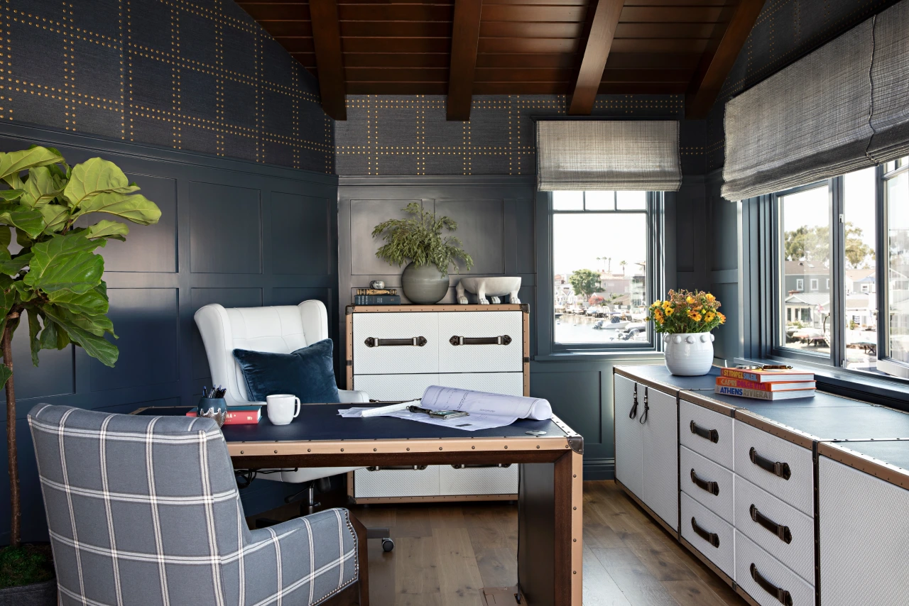 Eastbay Front home office with dark blue wainscoting, wood desk, plaid chair, and bright window light.
