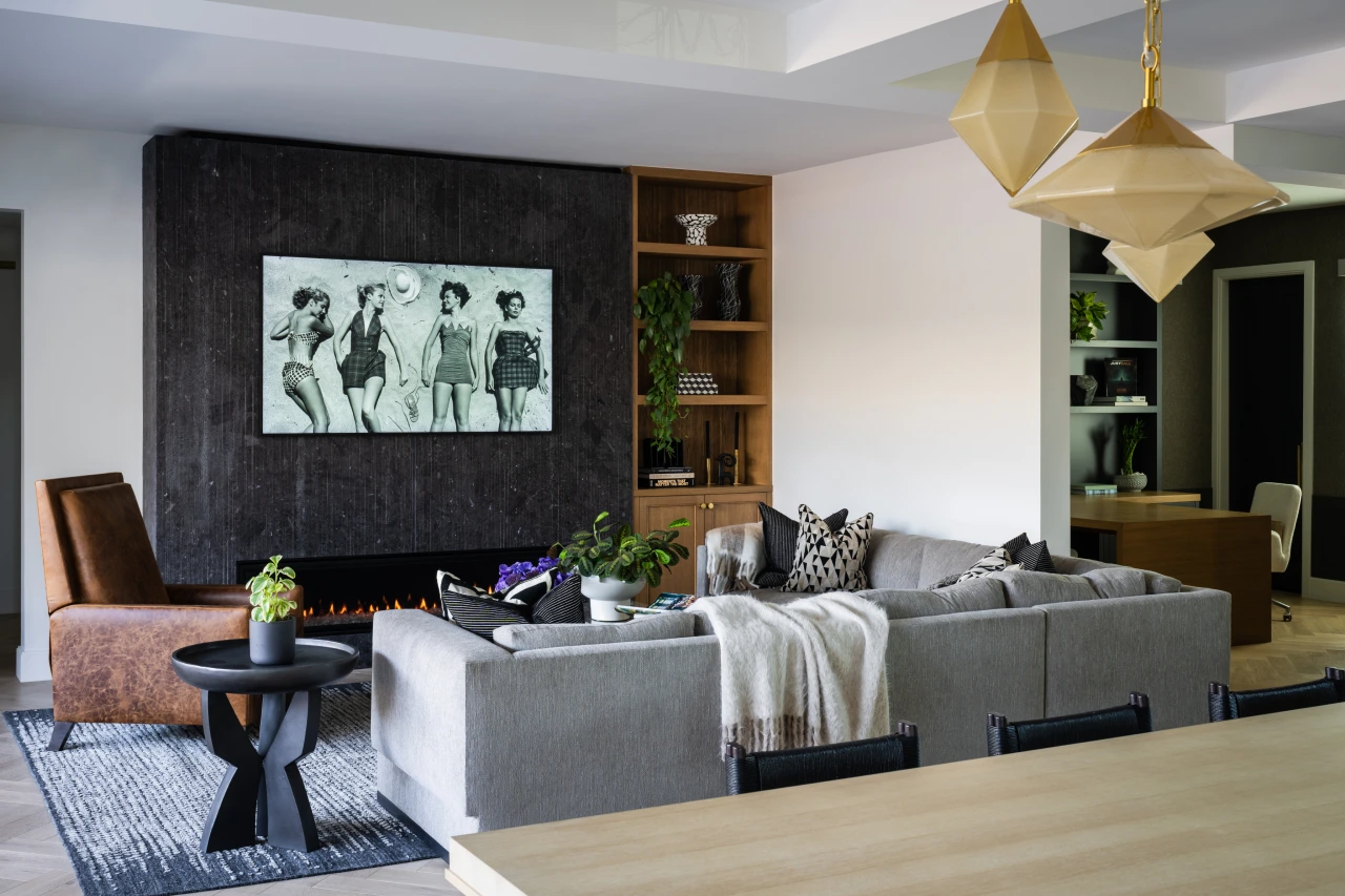 Herringbone Habitat living room with gray sofa, white walls, wood accents, and black marble TV surround.
