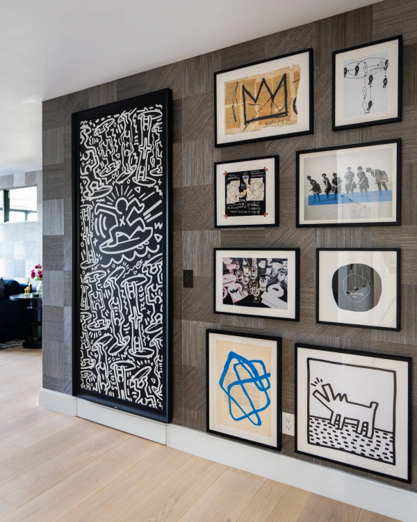 An artistic wall featuring 9 abstract artwork with a B&W and blue color scheme from Grace Blu's Herringbone Habitat Interior Design Project