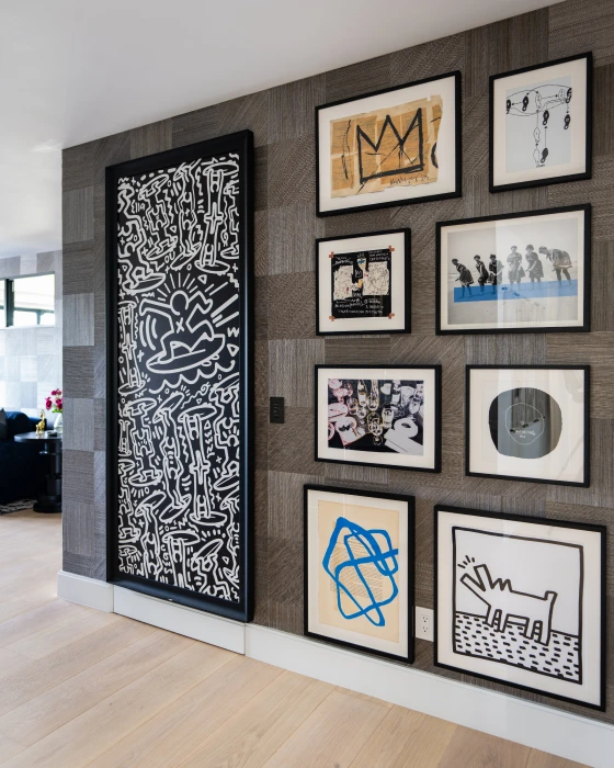 An artistic wall featuring 9 abstract artwork with a B&W and blue color scheme from Grace Blu's Herringbone Habitat Interior Design Project