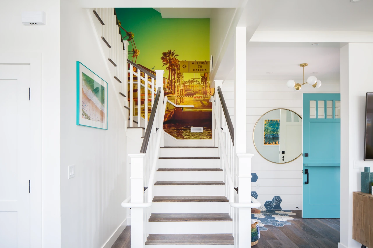 Staircase landing from lido house balboa cottage with blue accents, painted beach mural, blue floor tiles and natural light