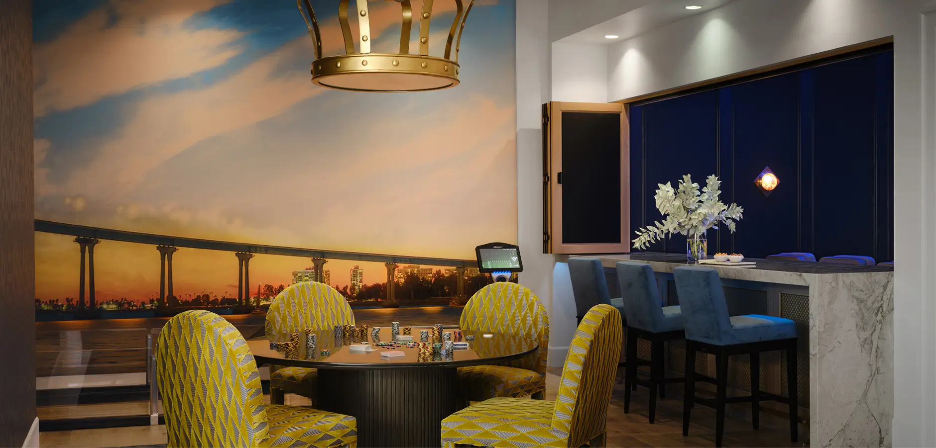 Grace Blu dining room with yellow table set, sunset wall photo, and contrasting blue-toned marble accent table.