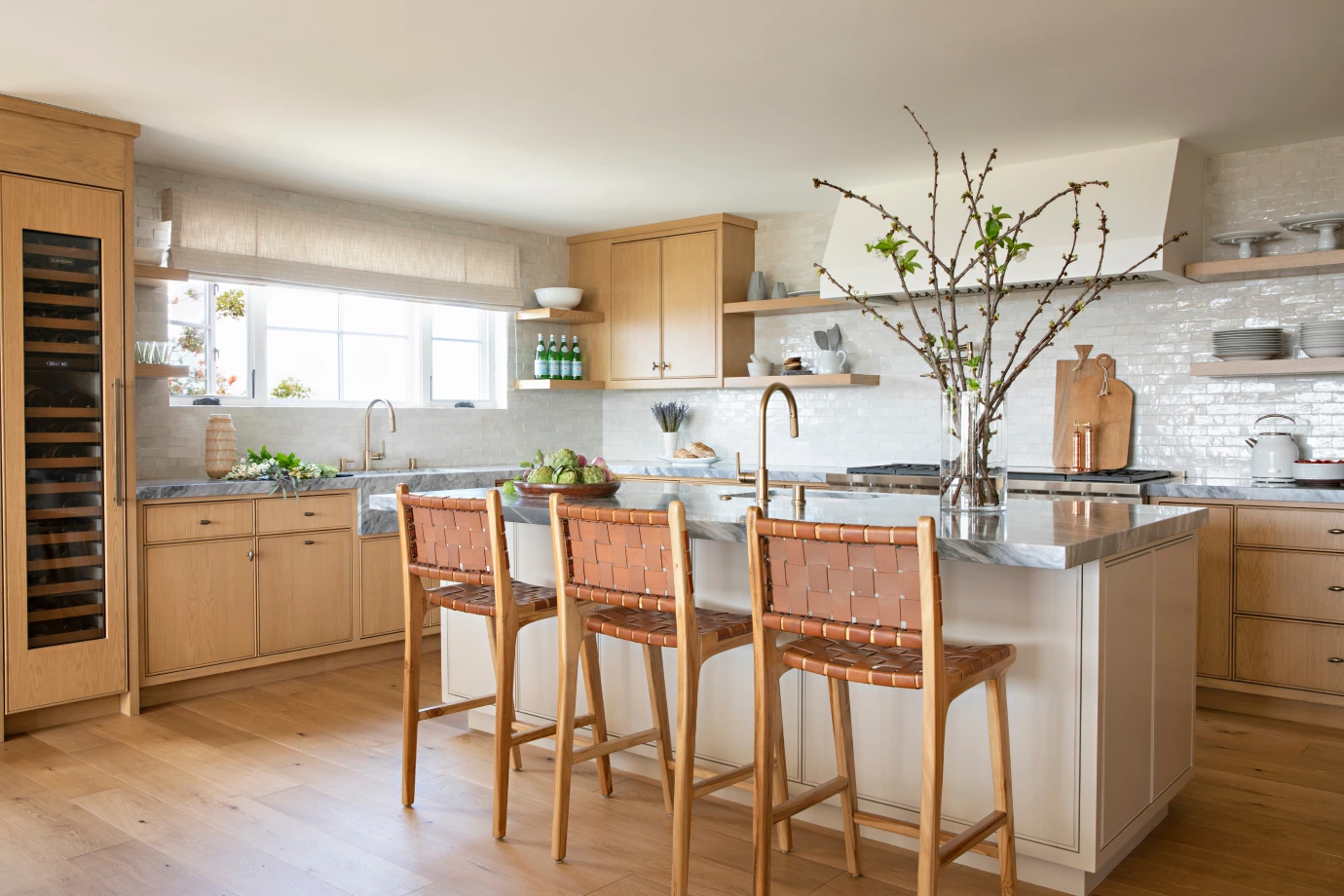 Park Ave kitchen with light wood drawers, gray-white swirly countertops, and white tiled backsplash by Grace Blu.