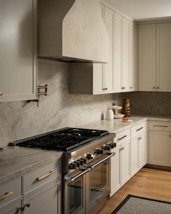 Kitchen from Grace Blu’s Interior Design Project Rattan Galore with white cabinetry, marble backsplash, and stainless steel gas range.