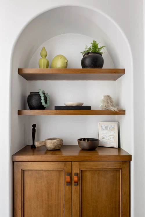 Styled niche with wood shelving and ceramic decor pieces from Grace Blu's Interior Design Project Via Jucar.