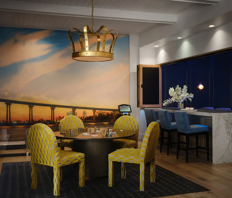 Dining nook with yellow chairs, sunset mural, and navy bar with marble counter by Grace Blu Interior Design.